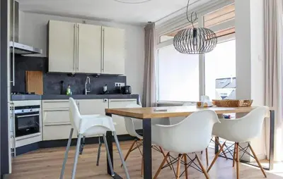 a kitchen with a dining table and white chairs at Duinzicht 2 in Bergen aan Zee