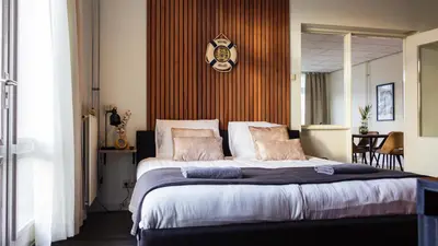 a bedroom with a large bed with a clock on the wall at The marine apartment near Amsterdam by Weltevreden Experience in Kortenhoef