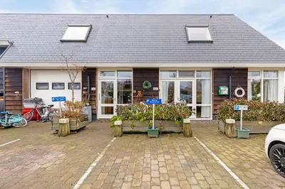 a building with a bunch of plants in a parking lot at The marine apartment near Amsterdam by Weltevreden Experience in Kortenhoef