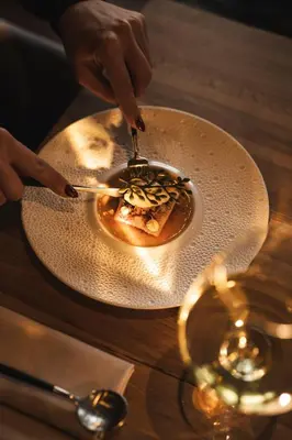a person eating a plate of food on a table at Villa de Duinen - Adults Only in Noordwijk aan Zee
