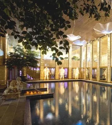 a large swimming pool in a building with a building at Villa de Duinen - Adults Only in Noordwijk aan Zee