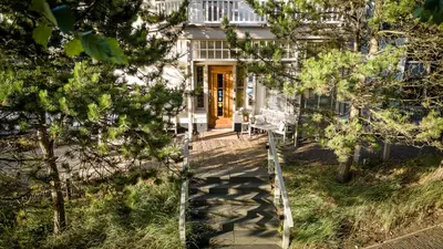 a house with a staircase leading to the front door at Villa de Duinen - Adults Only in Noordwijk aan Zee