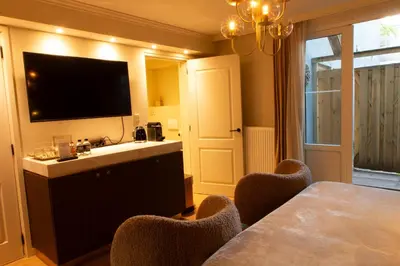 a dining room with a table with chairs and a television at B&B Midtown Amsterdam suites in Amsterdam
