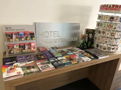 a table with many books on top of it at Hotel D'Amsterdam Leidsesquare in Amsterdam