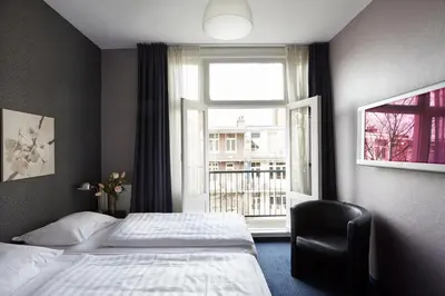 a hotel room with a bed and a window at Hotel D'Amsterdam Leidsesquare in Amsterdam