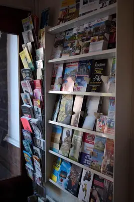 a book shelf filled with books and magazines at Hotel D'Amsterdam Leidsesquare in Amsterdam