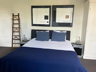 a bedroom with a blue and white bed with blue pillows at Room One-Twenty-One in Naarden
