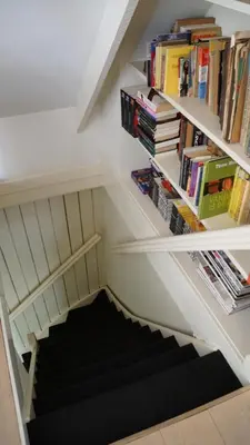 a staircase with bookshelves in a house at Room One-Twenty-One in Naarden