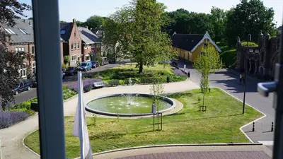 a view from a window of a park with a fountain at Room One-Twenty-One in Naarden