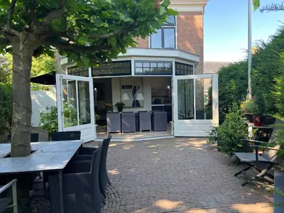 a patio with a table and chairs and a building at Room One-Twenty-One in Naarden
