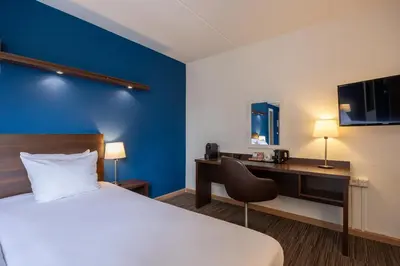 a hotel room with a bed and a desk at Amrâth Hotel Media Park Hilversum in Hilversum