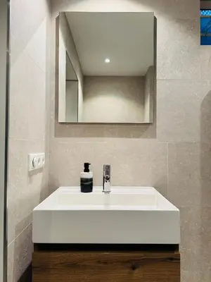 a bathroom with a white sink and a mirror at Hello Noordwijk - Souterrain Hoogwakersbosstraat 6 in Noordwijk aan Zee