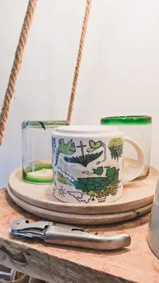 a coffee cup on a wooden table with a knife at JoyJoyJoy the Green Palm ecolicious studio in a in historic Canalhouse from 1729 with view on the canals in Amsterdam