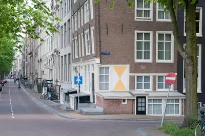 a tall brick building with a street sign in front of it at Hotel IX Nine Streets Amsterdam in Amsterdam