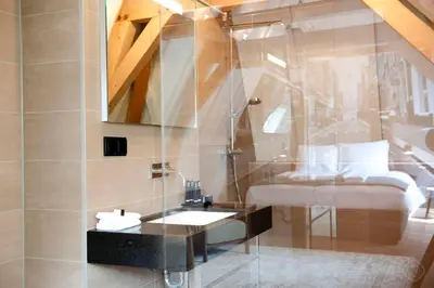a bathroom with a glass shower and a sink at Hotel IX Nine Streets Amsterdam in Amsterdam