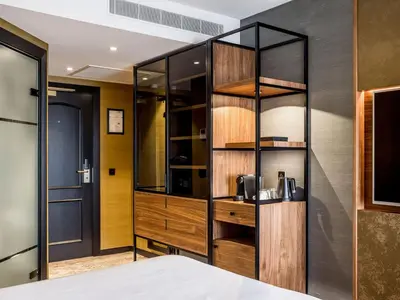 a room with a bed and a wooden cabinet at Alexander Hotel in Noordwijk aan Zee