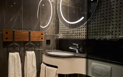 a bathroom with a sink and a mirror and towels at Alexander Hotel in Noordwijk aan Zee