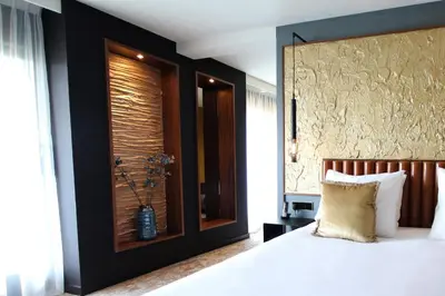 a bedroom with a white bed with a black wall at Alexander Hotel in Noordwijk aan Zee