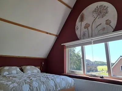 a bedroom with a bed and a window at Family House Wakker in Eemnes