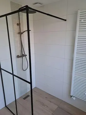 a shower with a glass door in a bathroom at Family House Wakker in Eemnes