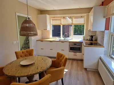 a kitchen with a table and chairs and a dining room at Family House Wakker in Eemnes