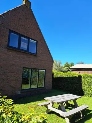a picnic table in front of a brick building at Family House Wakker in Eemnes