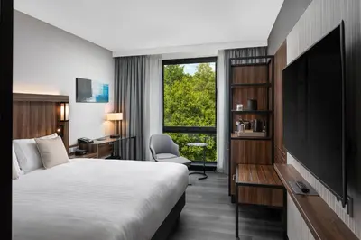 a hotel room with a bed and a tv at Courtyard by Marriott Amsterdam Airport in Hoofddorp