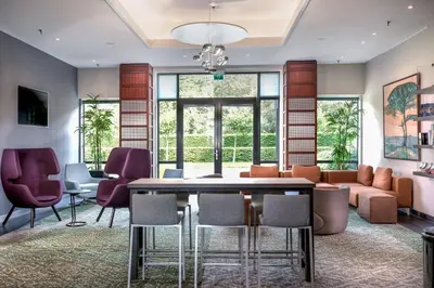 a living room with a table and chairs and a couch at Courtyard by Marriott Amsterdam Airport in Hoofddorp