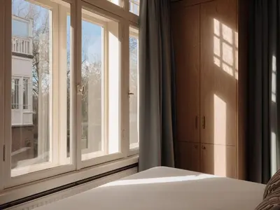 a bedroom with a bed and a large window at Adam's Museum House in Amsterdam