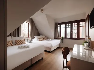 a hotel room with two beds and a table at Adam's Museum House in Amsterdam