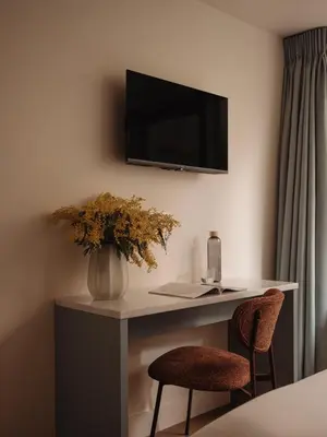 a room with a desk with a television and two chairs at Adam's Museum House in Amsterdam
