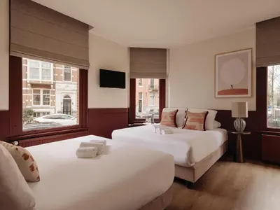 a hotel room with two beds and a couch at Adam's Museum House in Amsterdam