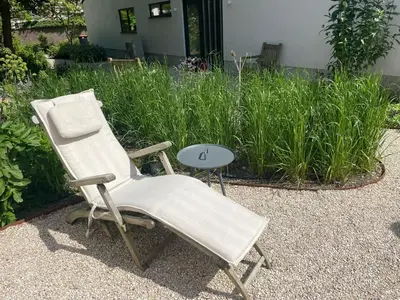 a white chair sitting next to a table at Huisje Hendrik in Baarn