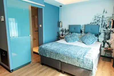 a bedroom with a large bed with blue walls at Palace Hotel Zandvoort in Zandvoort