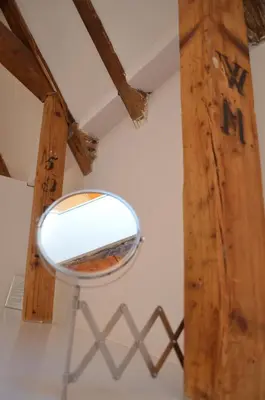 a mirror on a wall with a wooden beam at Rembrandtplein Bed & Breakfast in Amsterdam
