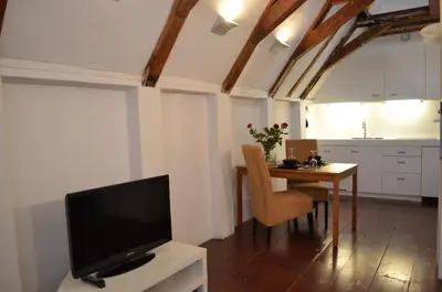 a living room with a television and a table with chairs at Rembrandtplein Bed & Breakfast in Amsterdam