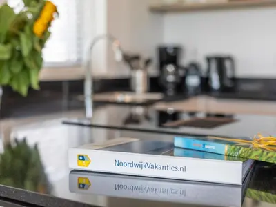a stack of books sitting on top of a table at Holiday Home Putter Comfort by Interhome in Noordwijk