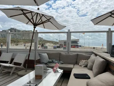 a living room with a couch and an umbrella at Holiday Home Putter Comfort by Interhome in Noordwijk