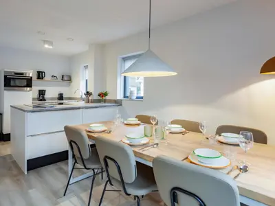 a dining room table with chairs and a kitchen at Holiday Home Putter Comfort by Interhome in Noordwijk