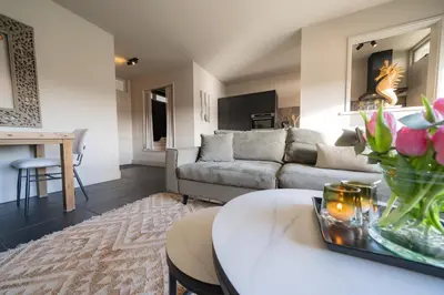 a living room with a couch and a table at Hello Noordwijk - Appartement Duindamseweg 14E in Noordwijk aan Zee