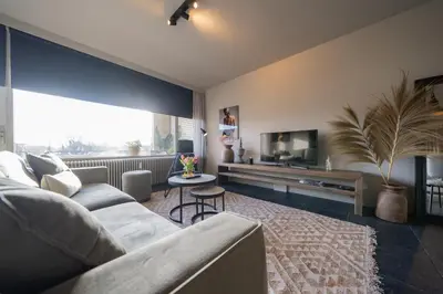 a living room with a couch and a tv at Hello Noordwijk - Appartement Duindamseweg 14E in Noordwijk aan Zee