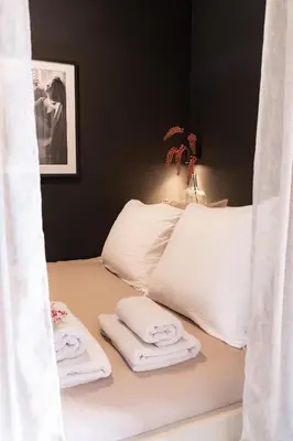 a bed with white sheets and towels on it at Hello Noordwijk - Appartement Duindamseweg 14E in Noordwijk aan Zee