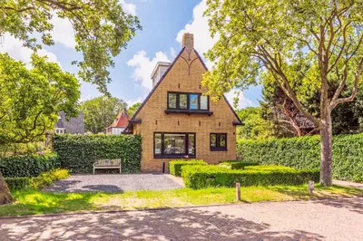 an exterior view of a house with a hedge at Huize Nassau in Bergen