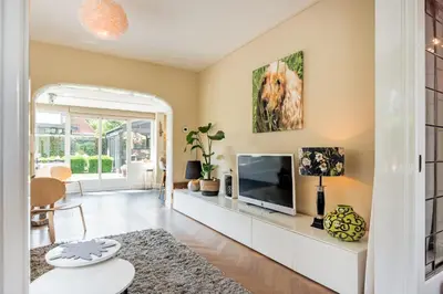 a living room with a flat screen tv and a couch at Huize Nassau in Bergen