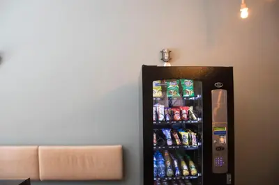 a black refrigerator with soda and drinks in it at Amsterdam Hostel Annemarie in Amsterdam