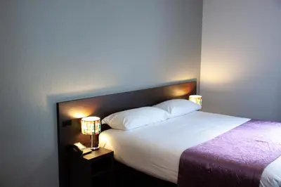 a bedroom with a large bed with two lamps at Hotel Luxer in Amsterdam