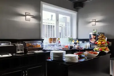 a kitchen with a counter with plates and food at Hotel Luxer in Amsterdam