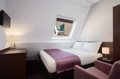 a hotel room with a bed and a window at Hotel Luxer in Amsterdam