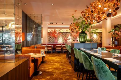 a restaurant with green chairs and tables and a bar at Van der Valk Hotel Schiphol in Hoofddorp
