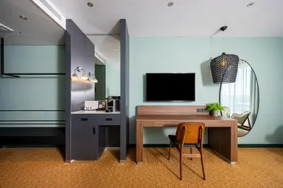 a room with a desk with a television and a chair at Van der Valk Hotel Schiphol in Hoofddorp